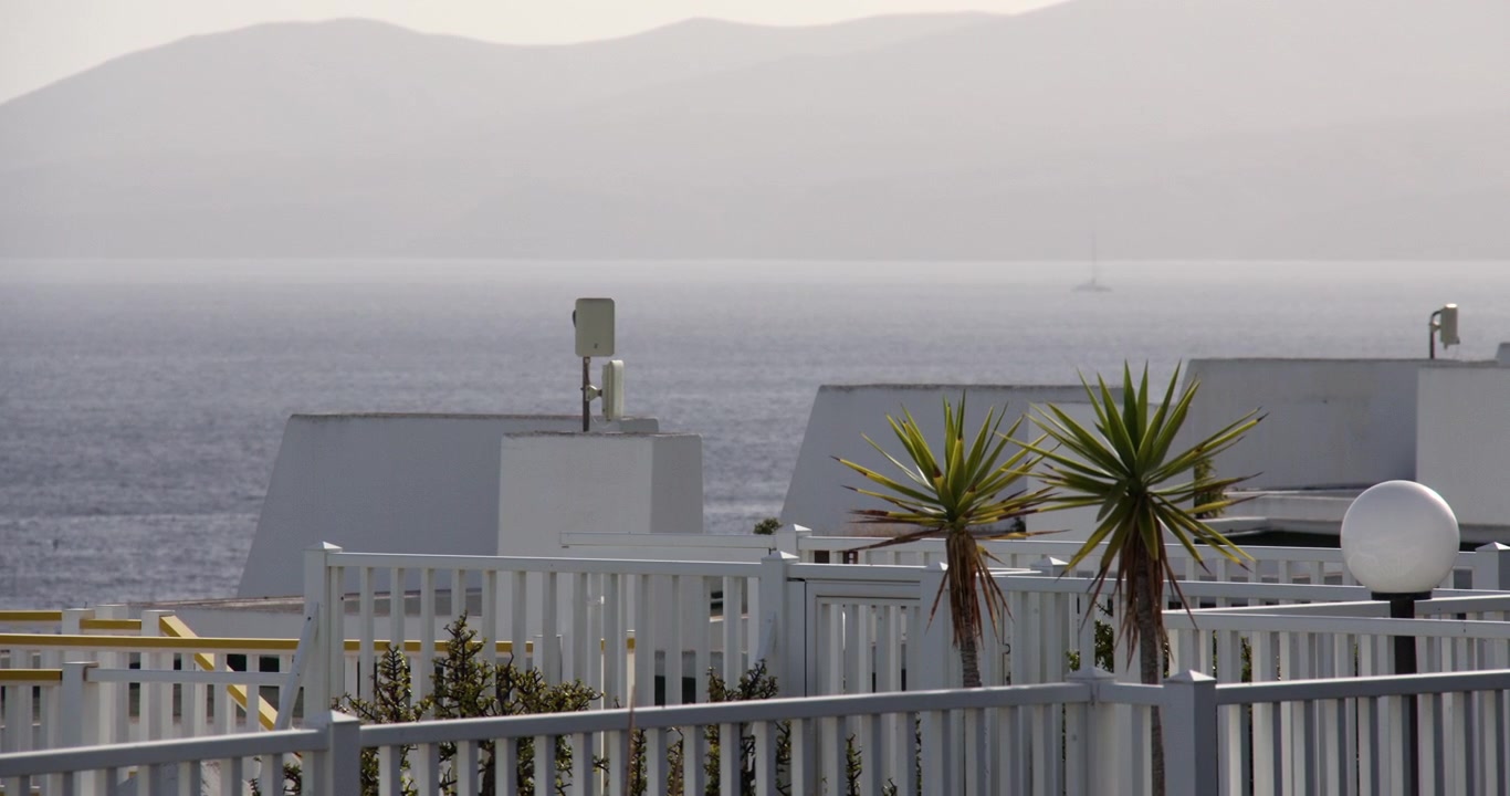 Toma panorámica mirando al oeste sobre los tejados de edificios encalados en Puerto del Carmen, Lanzarote, Islas Canarias