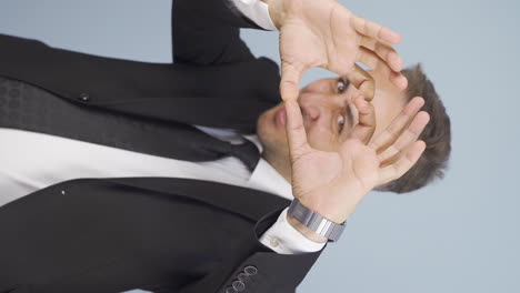 vertical video of businessman making heart at camera.