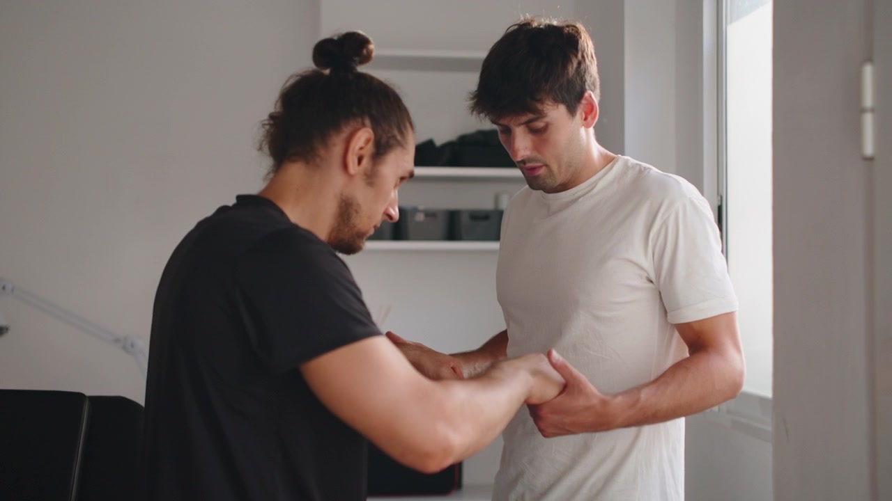 Physical Therapist Examining Patient's Hand in Clinic