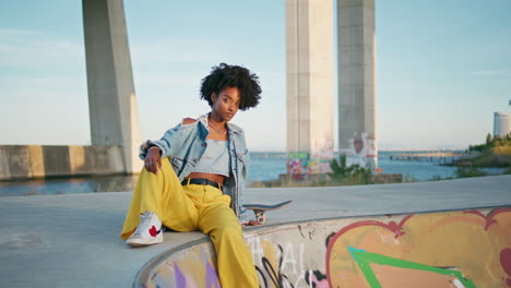 cool  model posing at urban backdrop close up. hipster sitting skate park