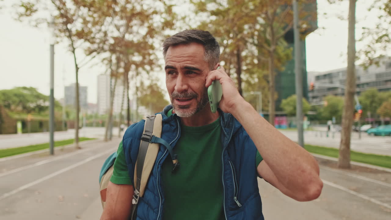 Man with Backpack Talking on Phone in Urban Setting