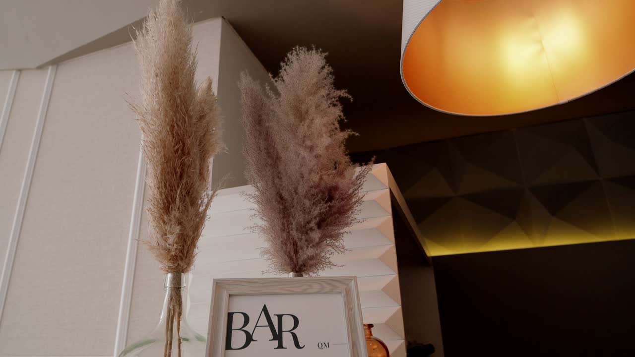 Pampas grass in vases decorates modern bar area with warm ceiling light