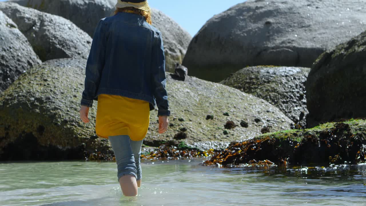 mujer caminando sobre el agua en la playa 4k