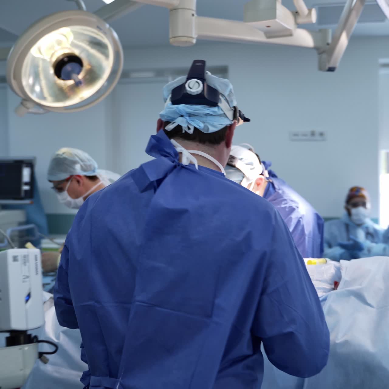 Following the doctor equipped for surgery. Surgeon walks into the operational room where the surgery takes place