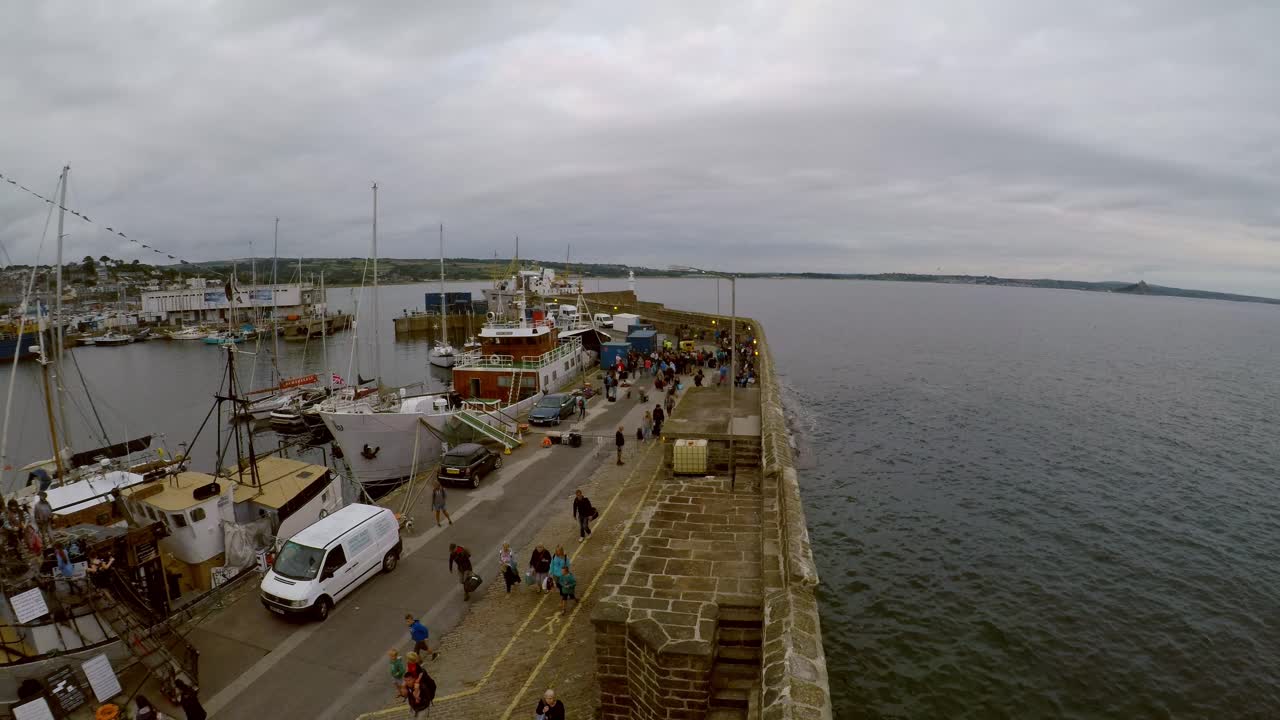 Penzance Harbour as a ship moors and people unload and depart the gangway