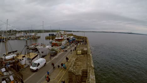 penzance harbour as a ship moors and people unload and depart the gangway