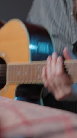 man with long hair and beard playing acoustic guitar