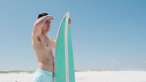 man holding a surfboard on the beach