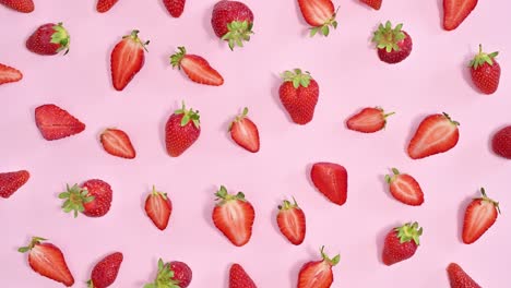 patrón de fresas orgánicas maduras en fondo rosa pastel. colocación plana de movimiento de parada