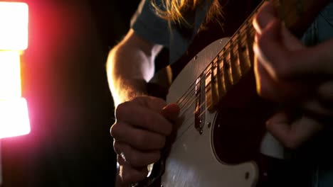 close up of man playing electric guitar