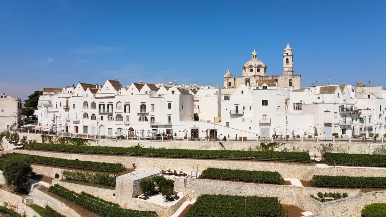 vista aérea de las casas de la aldea de locorotondo, una ciudad tradicional italiana en la cima de una colina, en un soleado día de verano