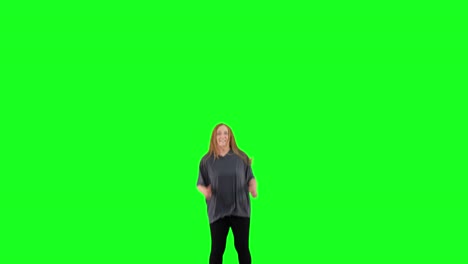 a mature woman bounces on a trampoline in front of a green screen