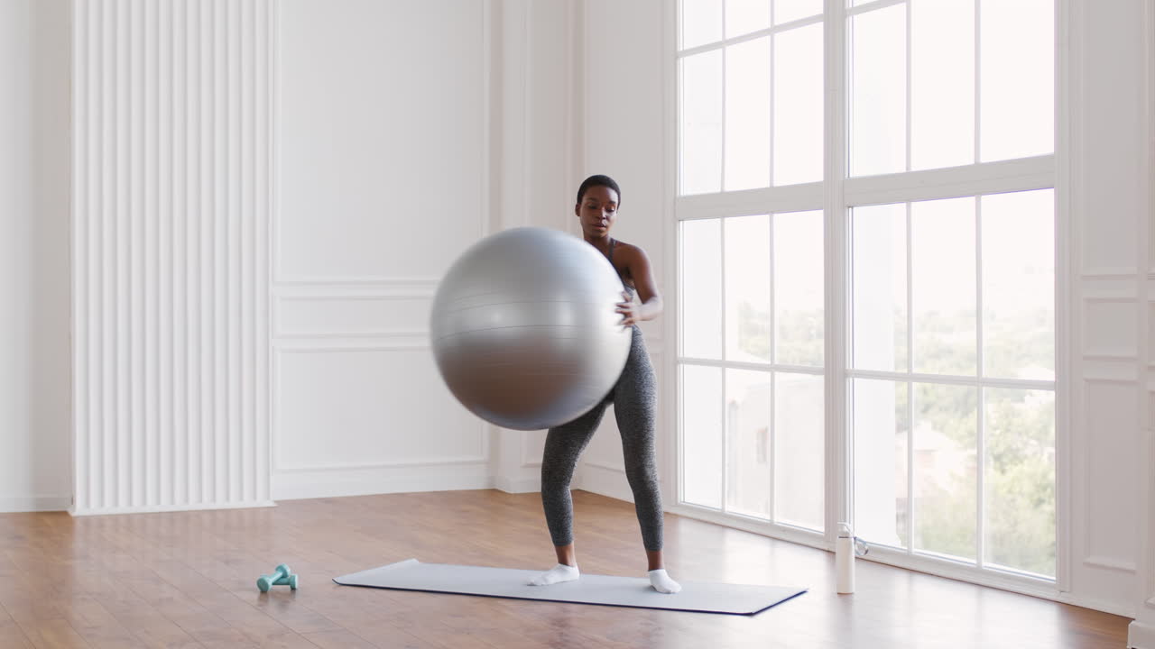 Woman exercising with a yoga ball in a studio