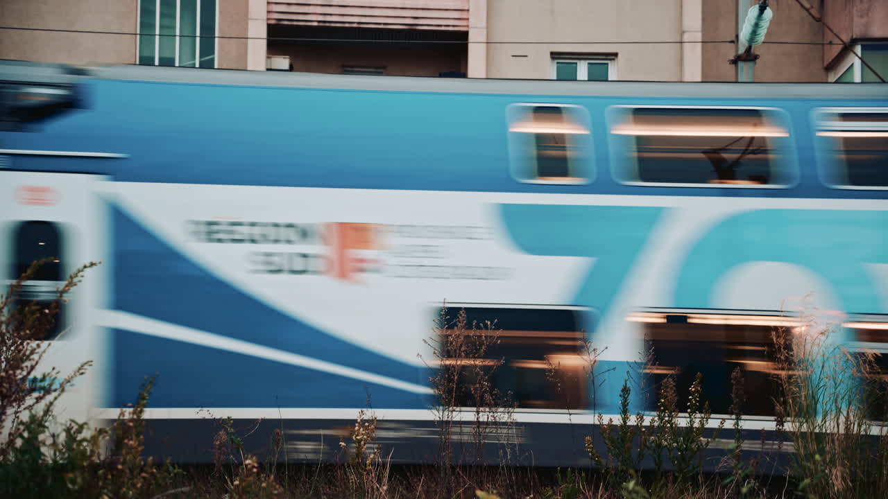 Dynamic shot of a fast train passing by, creating motion blur and urban energy