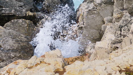 sea waves breaks through hole in rocky shore