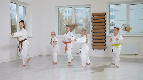 niños en kimono blanco en la clase de artes marciales