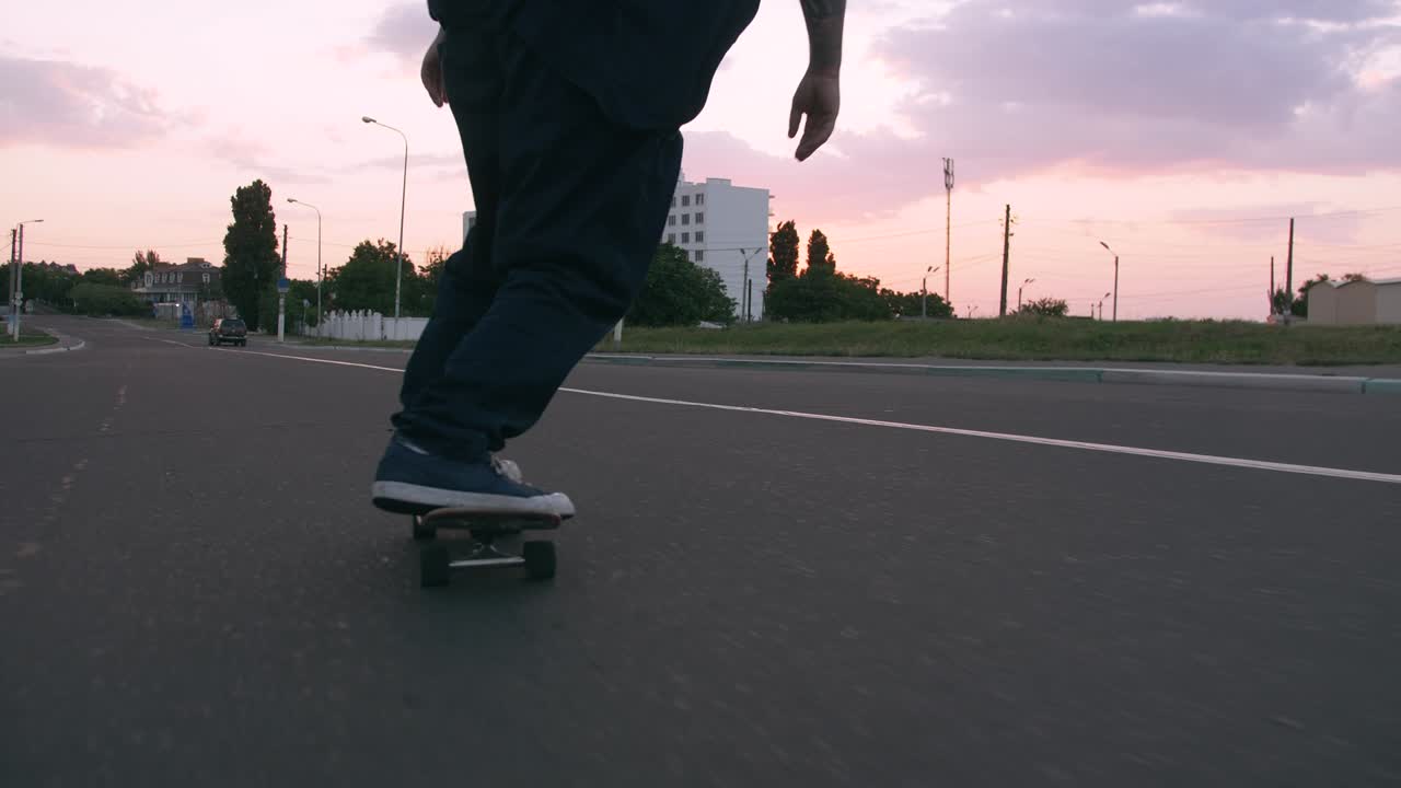grupo de jóvenes patinando en la carretera temprano en la mañana, toma cinematográfica, cámara lenta