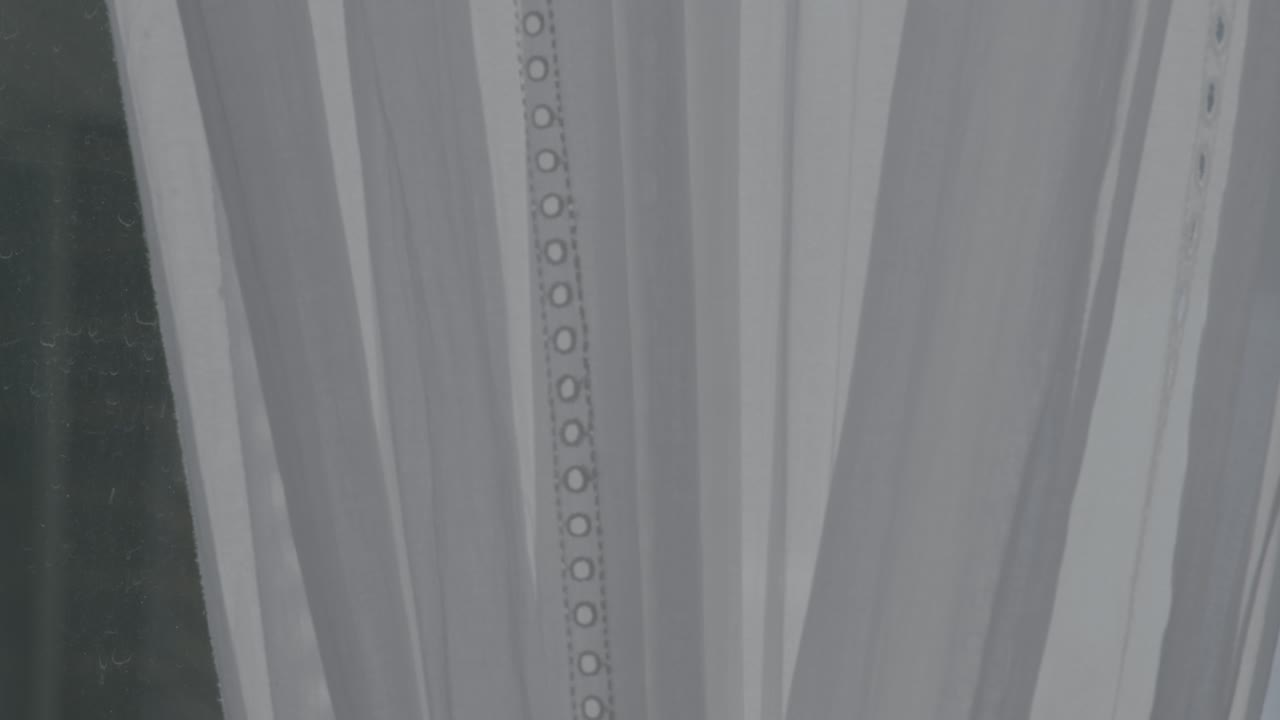 Detailed view of intricate lace and soft fabric of a wedding dress, lit by gentle natural light. The focus reveals exquisite patterns and texture, emphasizing luxury and elegance