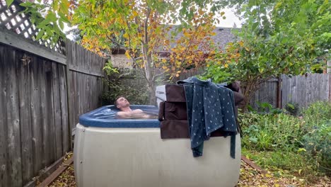 Man-Relaxing-On-Outdoor-Hot-Bathtub-At-The-Yard