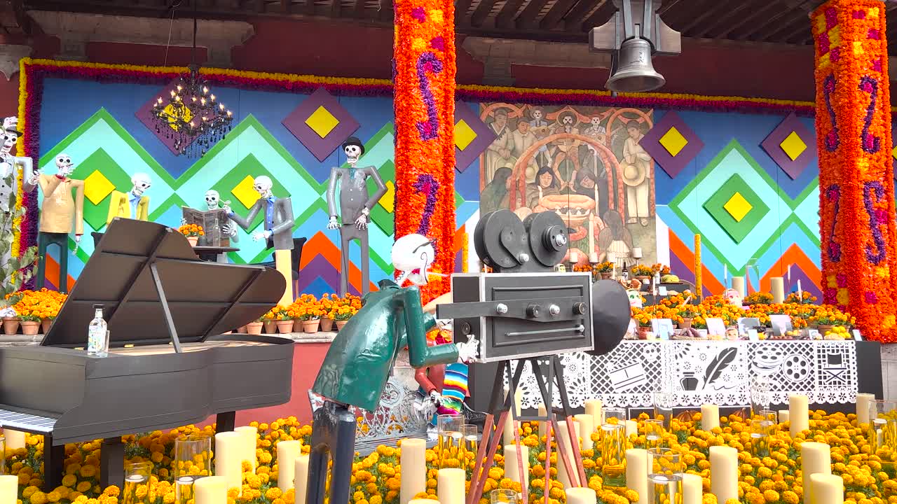 ofrenda del día de los muertos frente al edificio del gobierno en el ayuntamiento de coyoacán en la ciudad de méxico que consta de varias flores de cempasúchil, velas y calaveras vestidas como personajes mexicanos famosos