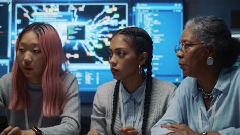 a dynamic collaboration in technology: a diverse team engaging in serious discussion over data analysis and coding in a modern tech environment