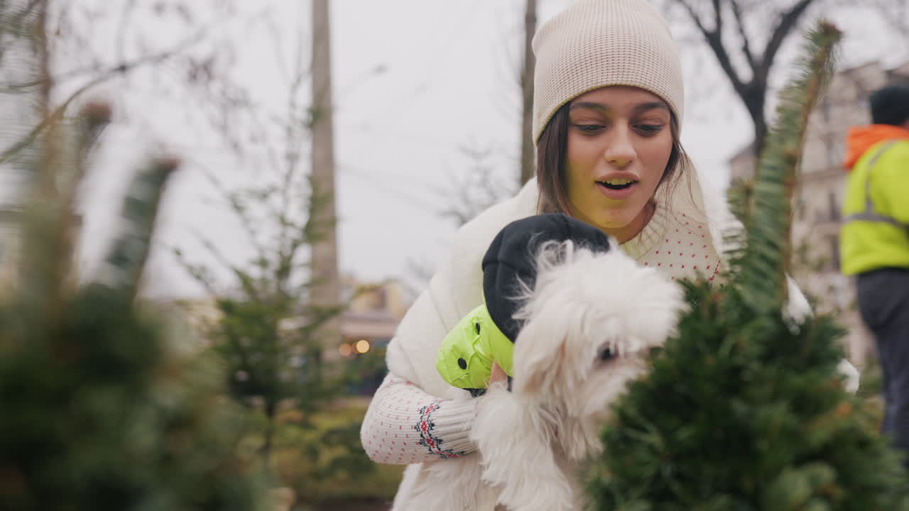 mujer con perro eligiendo un árbol de navidad