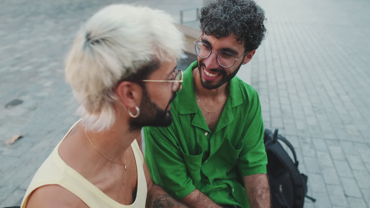 Happy Young Men with Glasses Talking and Laughing Outdoors