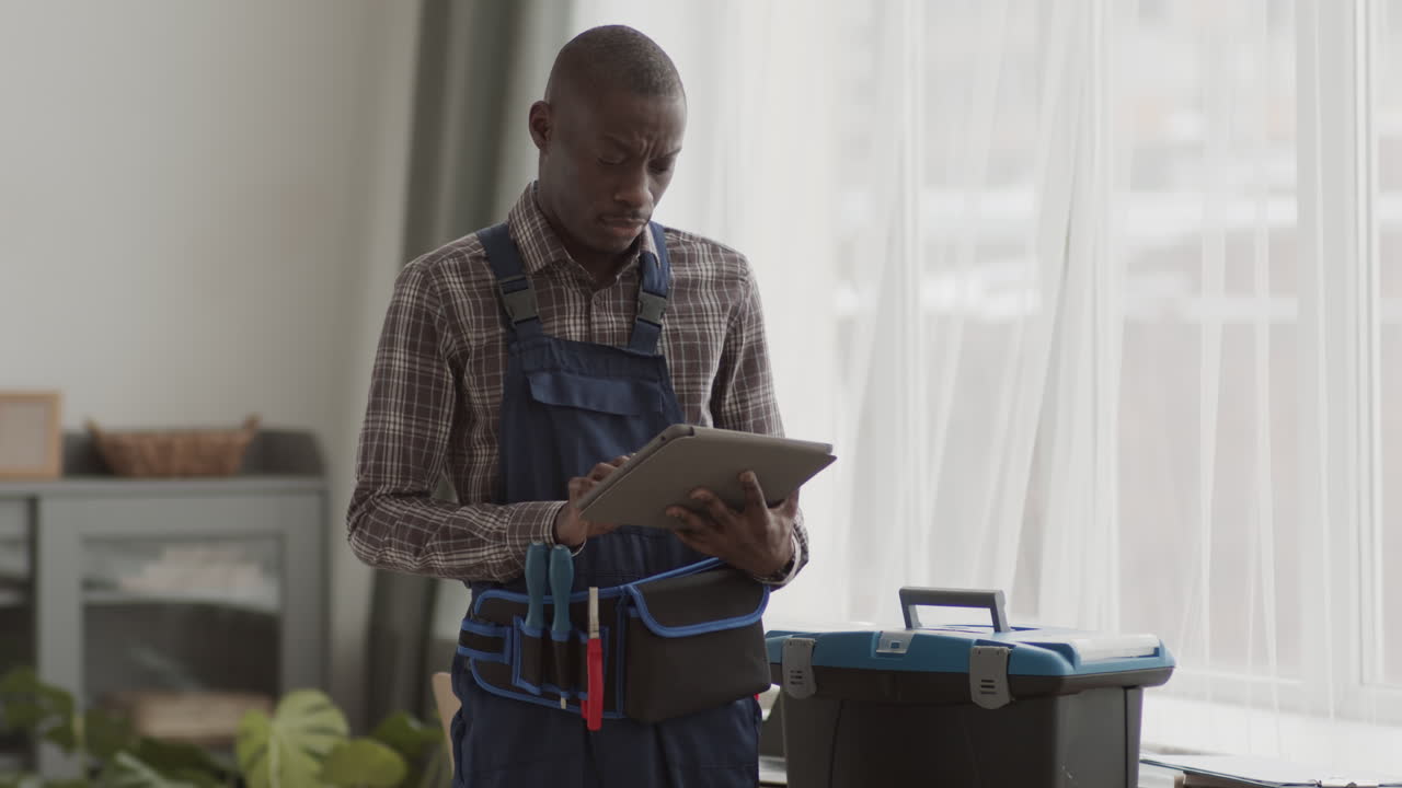 Handsome African-American Handyman Using Digital Tablet