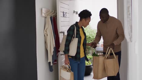 Video-of-happy-african-american-couple-returning-home-with-shopping-bags