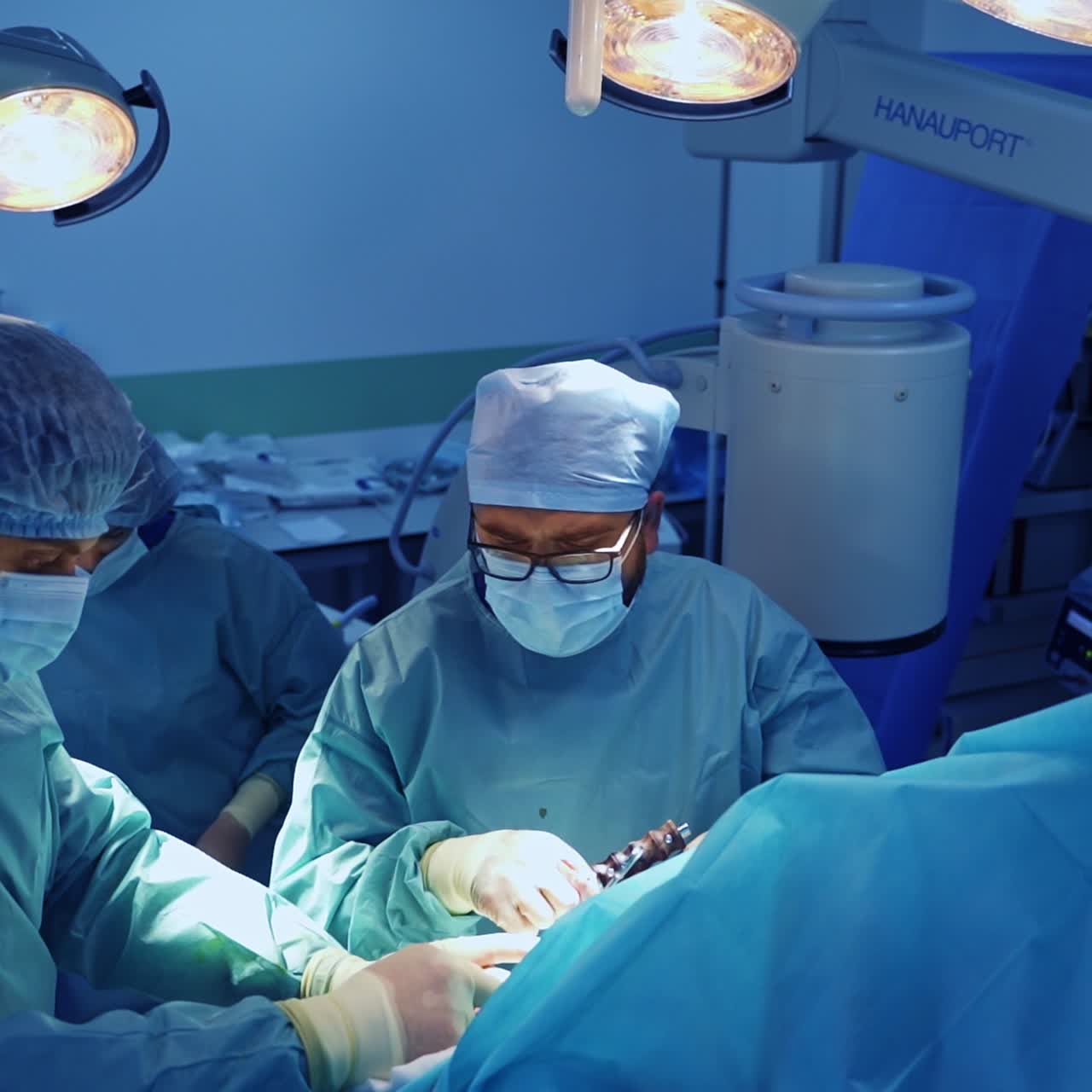 Pair of doctors use diverse instruments in the trauma operation. Surgery nurse passing the tools to doctors. Top view