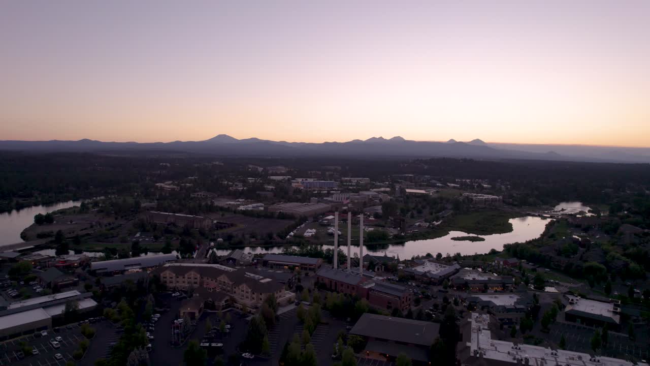 Zachód słońca w Bend, Oregon – ujęcie z drona z panoramowaniem od lewej do prawej przedstawiające Stary Młyn, rzekę Deschutes i Góry Kaskadowe