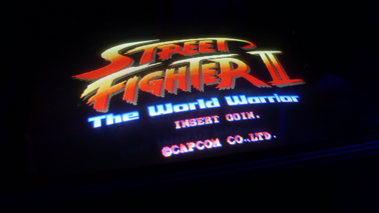 Street Fighter 2 arcade machine in an arcade. The retro video game is displaying insert coin on a CRT screen