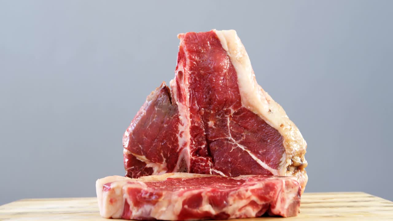 Bistecca cruda sul bordo di legno