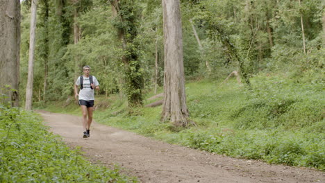 Man-in-shorts-running-on-trail-in-forest