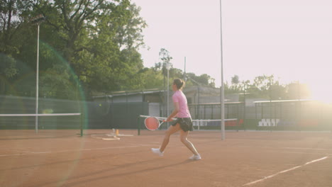 Young-Caucasian-woman-playing-tennis-on-a-court-returning-a-ball-in-slow-motion