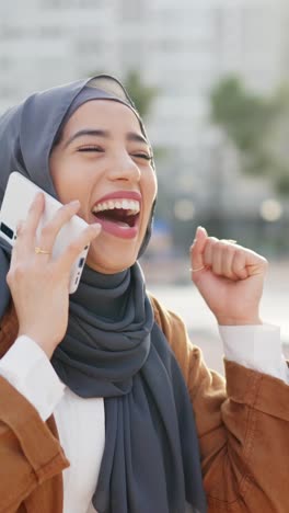 joyful muslim woman celebrates good news on a phone call outdoors