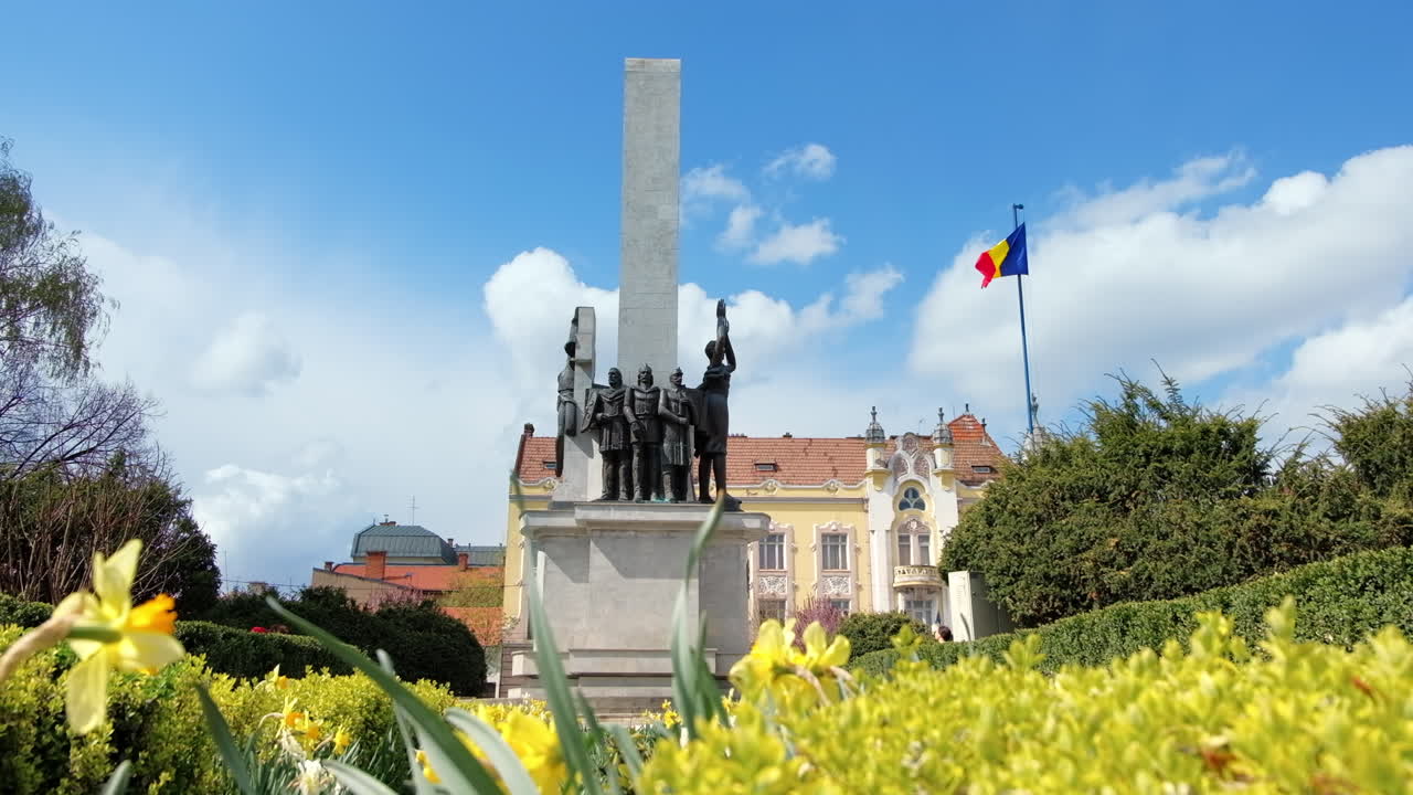 O Glória do Monumento ao Soldado Romeno localizado na Praça Avram Iancu, no centro de Cluj Napoca, Romênia. Vegetação e flores em frente a ele.