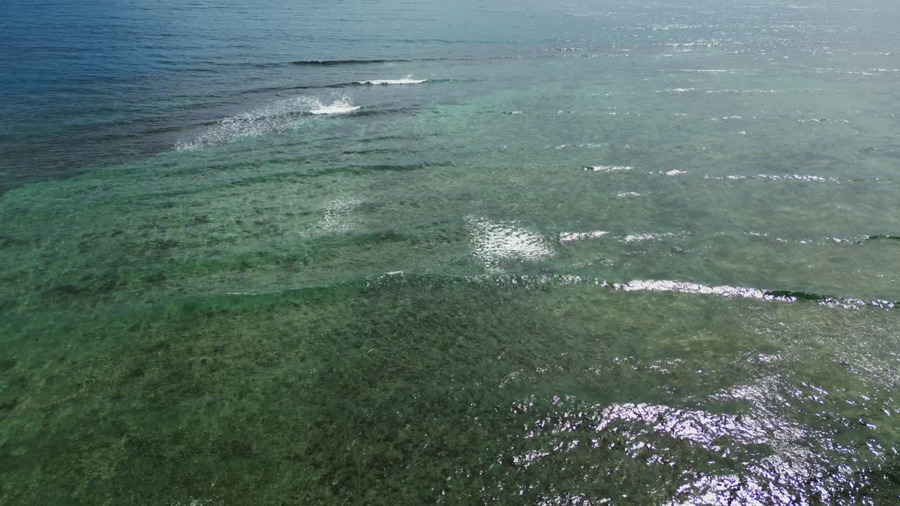Idyllic aerial flyover of ocean waves passing and crashing over shallow coastal reef in Catanduanes, Philippines