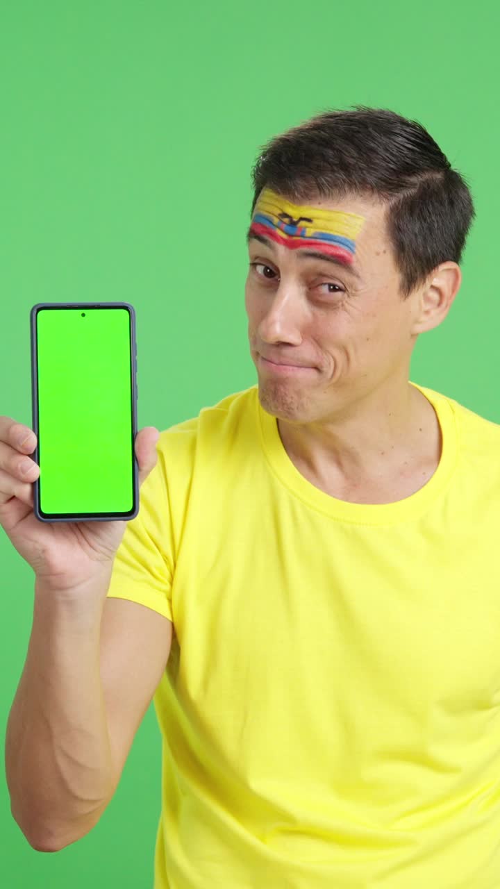 Ecuadorian supporter looking at his mobile smiling and showing it