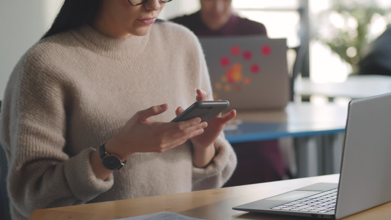 mujer navegando por la web en un teléfono inteligente en la oficina