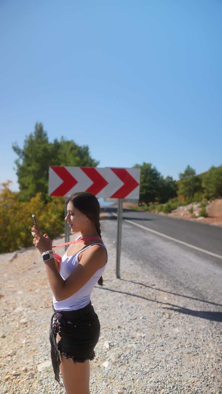 mujer tomando fotos en un viaje por carretera panorámico