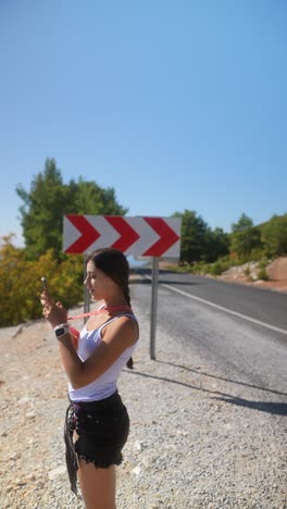 woman taking pictures on a scenic road trip