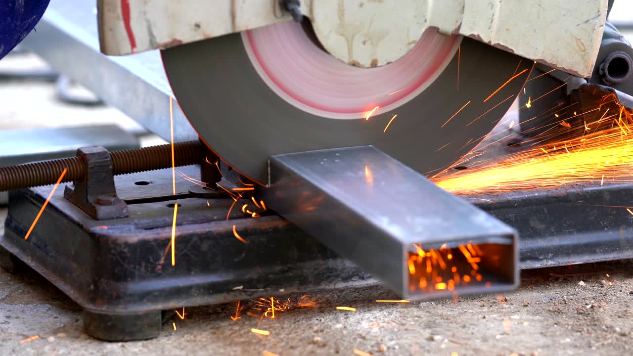 건설 노동자 용접기 손의 4k 클로즈업 은 철강 바를 절단하고 용접에서 불꽃을 만들기 위해 전기 각성 회전기를 사용합니다.