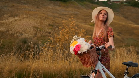 Mädchen-Im-Mittleren-Plan-Im-Kleid-Geht-Mit-Fahrrad-Und-Blumen-Auf-Dem-Feld