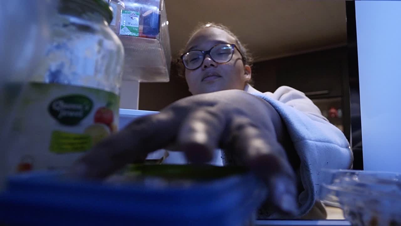 mujer sacando la mantequilla de la nevera para hacer un bocadillo