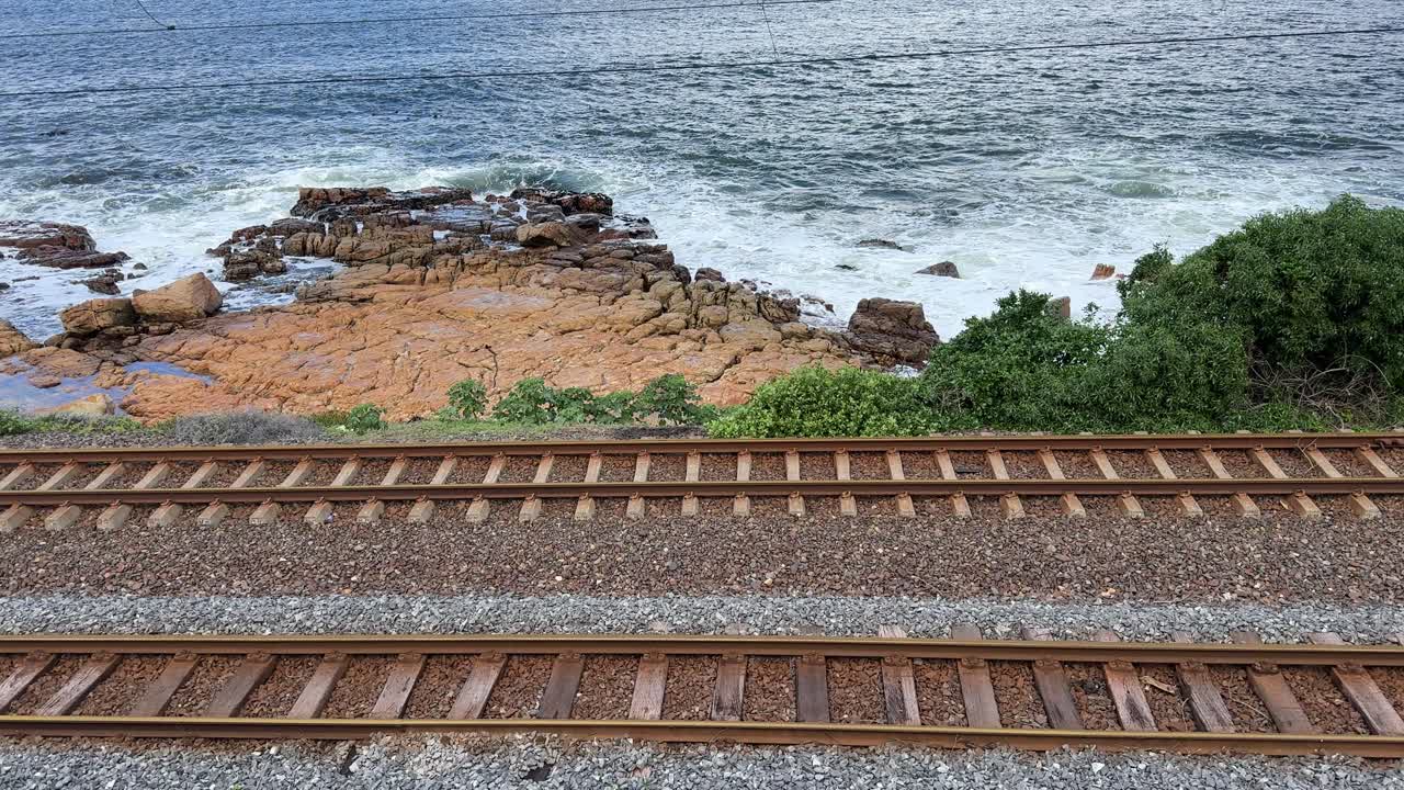 Train tracks next to the ocean near Cape Town, South Africa along the False Bay train line.