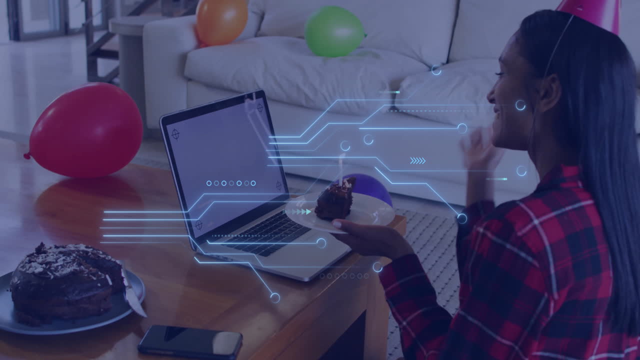 Person enjoying cake at home with digital network animation over laptop
