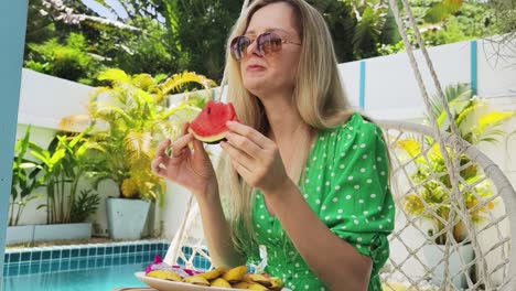 woman enjoying a watermelon by the pool