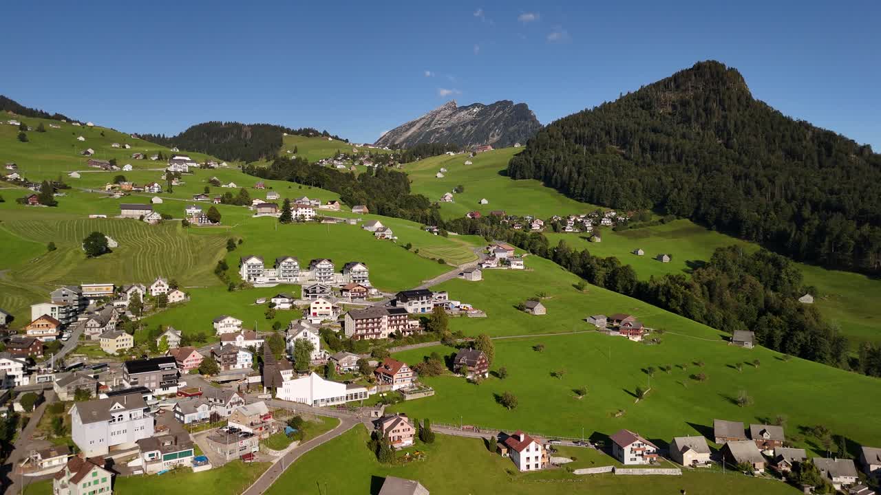 Alpine valley holiday destination Switzerland mountain resort village, aerial