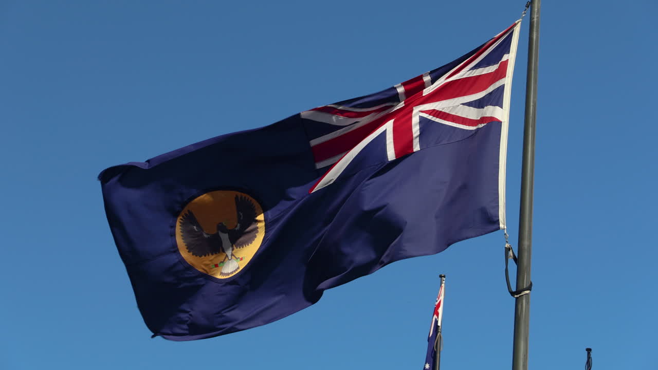 The South Australian flag waves proudly in the wind, showcasing state pride and Australian heritage. Perfect for projects related to South Australia, travel, or Australian culture.